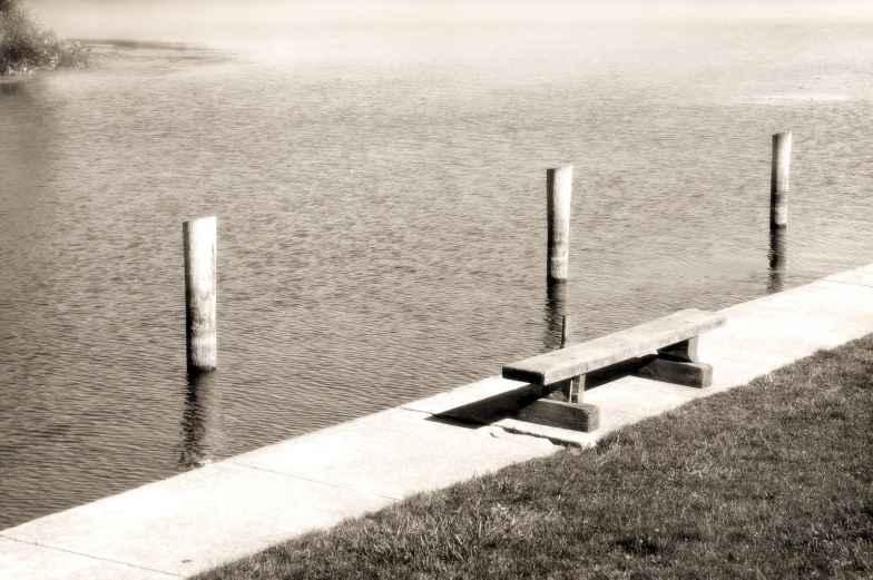 three wooden benches are out on the side of a lake