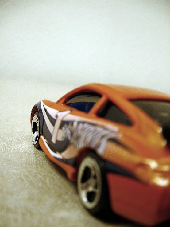 the toy car has a ze and orange stripe on it