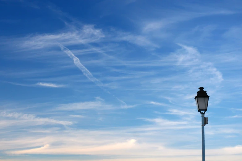 two street lamps and a blue sky with some clouds