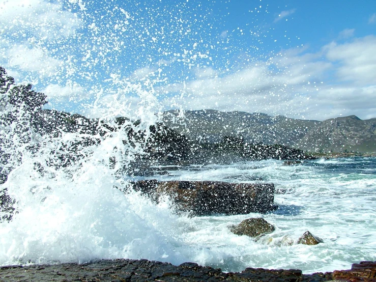 a body of water that is splashing onto a rock