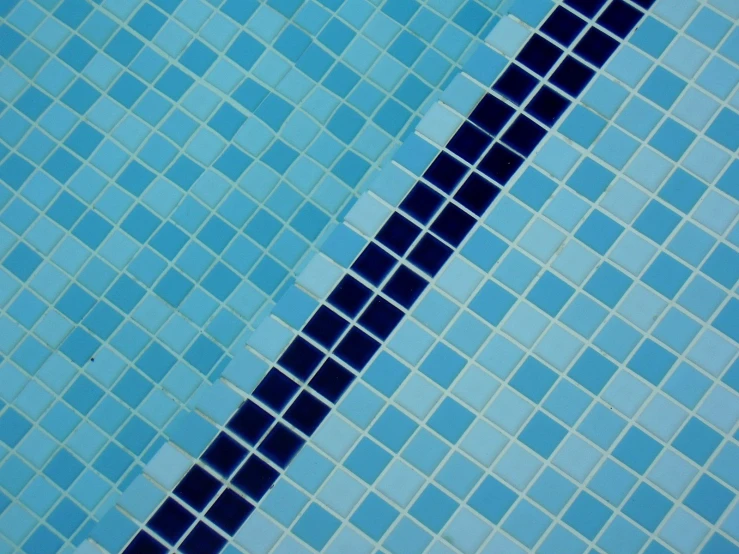 an orange umbrella near a blue tiled swimming pool