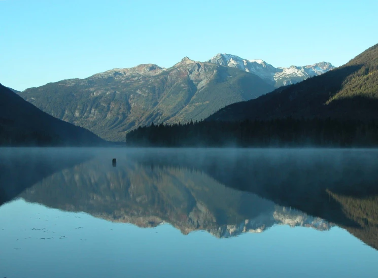 the sky and mountains have a mist in the water