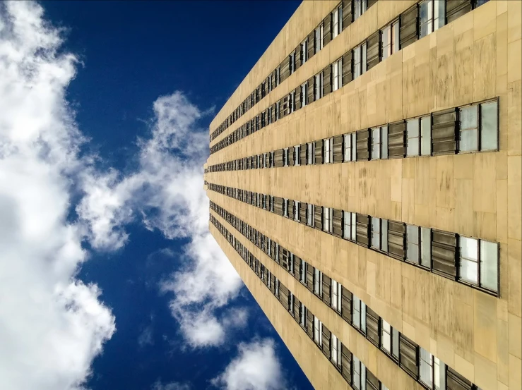 a tall building sitting under a partly cloudy blue sky