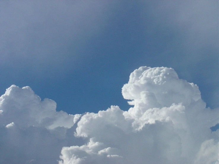 a cloud full of small white clouds is flying through the sky