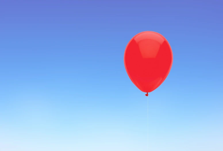 the lone balloon is against the blue sky