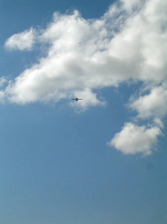 an airplane flies high in the air, with very clouds