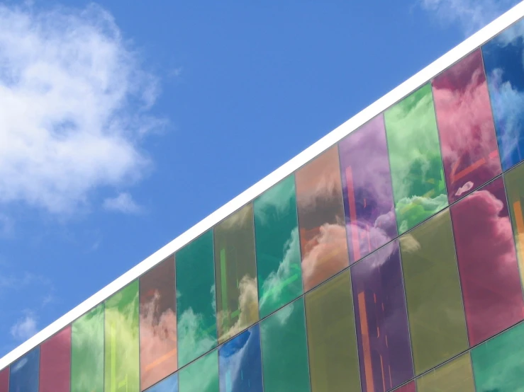 the side of a glass building with multi colored bars of glass on it