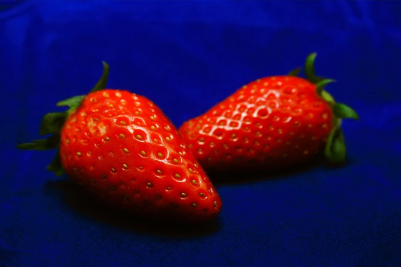 there are two red strawberries sitting together