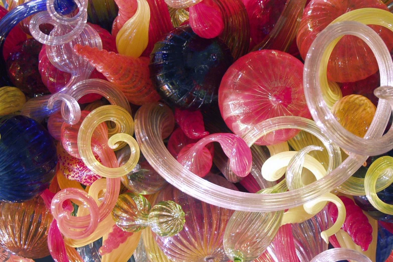 many colorful glass pieces are piled on top of each other