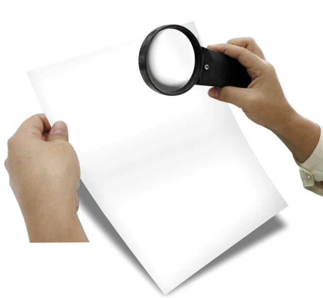 a man is holding a magnifying glass over a sheet of paper