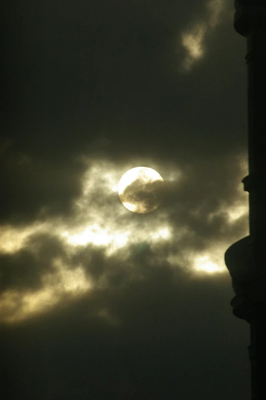 a full moon is visible between dark clouds