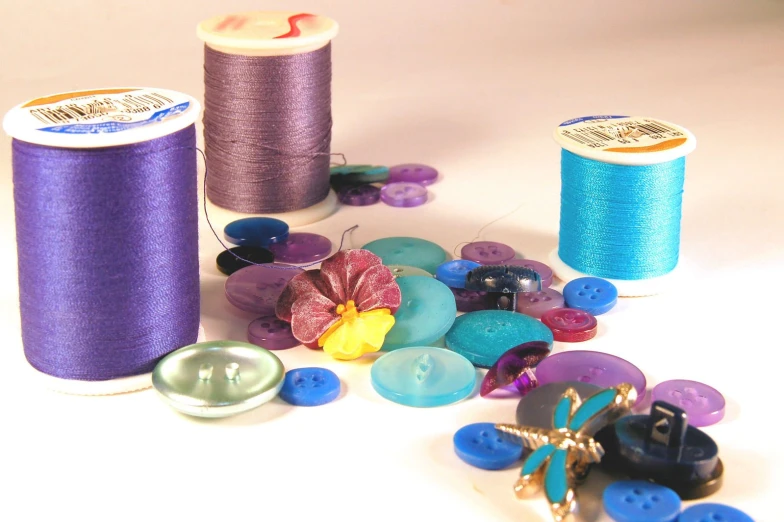 a table with spools of thread, ons, and small flowers