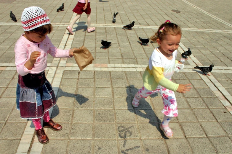 two s are playing with birds outside