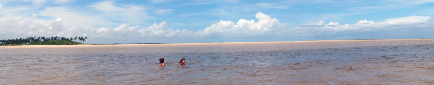 people are walking through the water on an overcast day