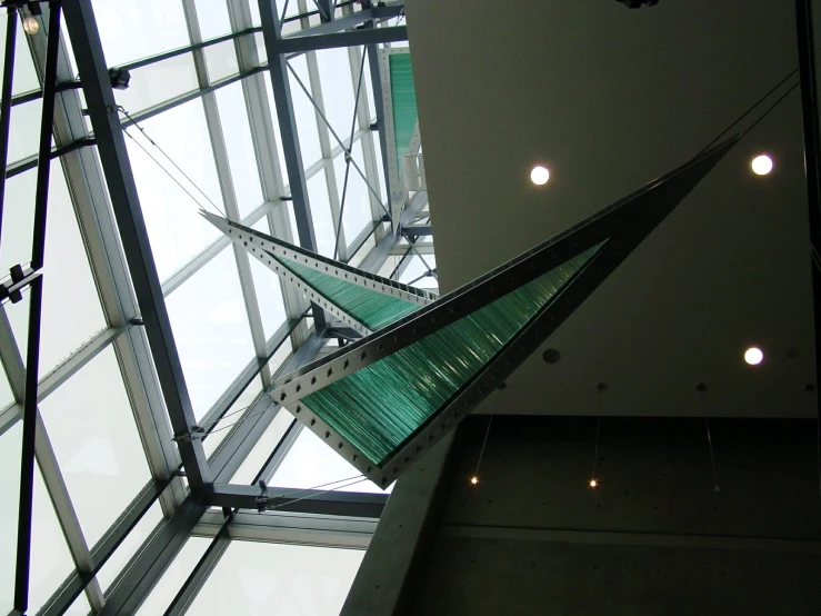 green object hanging from ceiling above glass in an office building