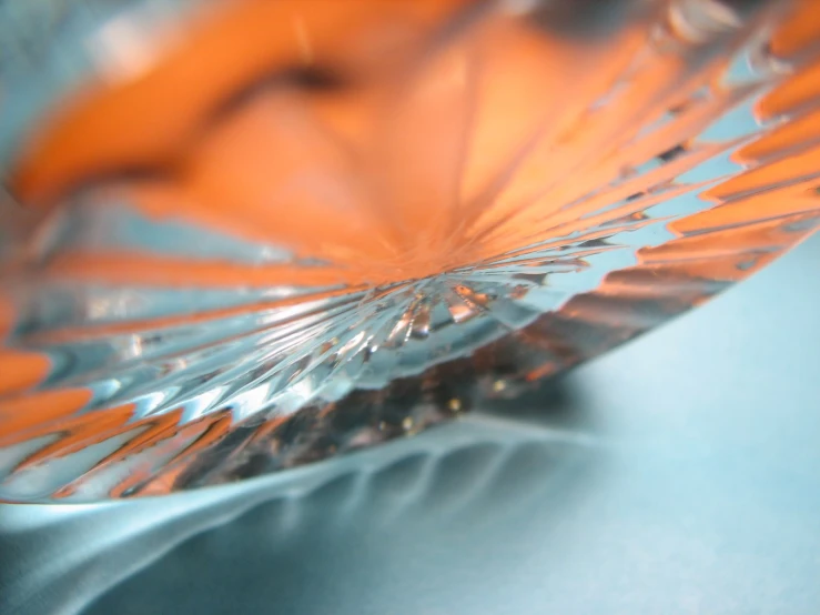 an orange vase sits on a blue surface