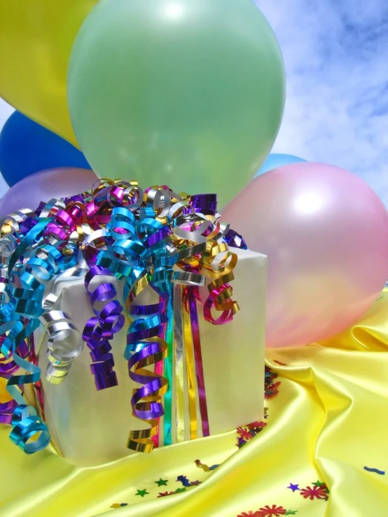 many balloons with streamers, tied ribbon, and bow