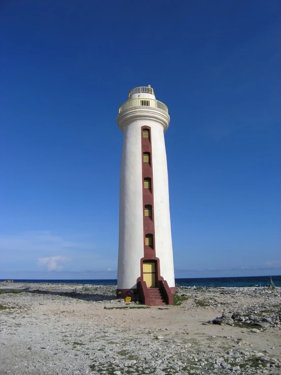 the tall light house is in the middle of the beach