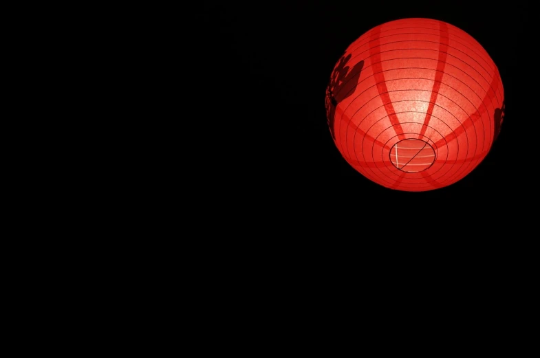 a red lantern is lit up against the dark sky