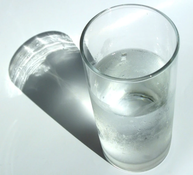 a glass of water is shown against a white background