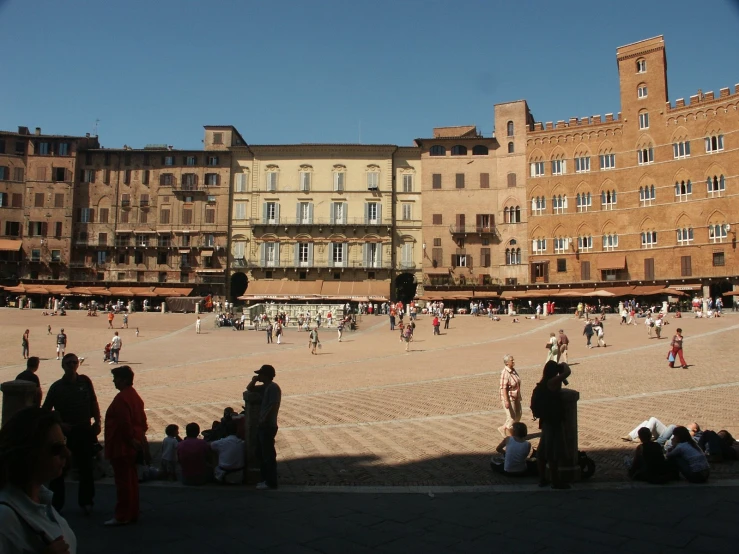 a group of people sitting in front of buildings