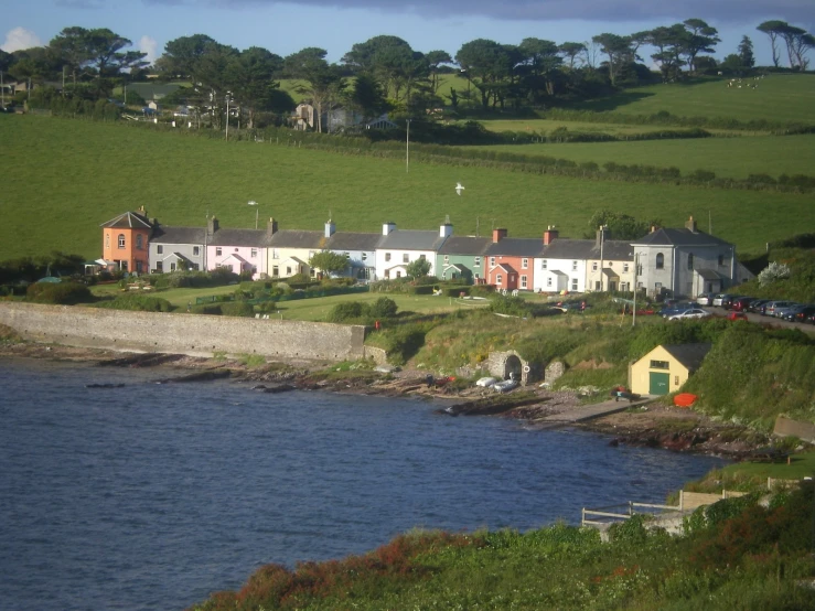 several houses near the water in an area of farmland