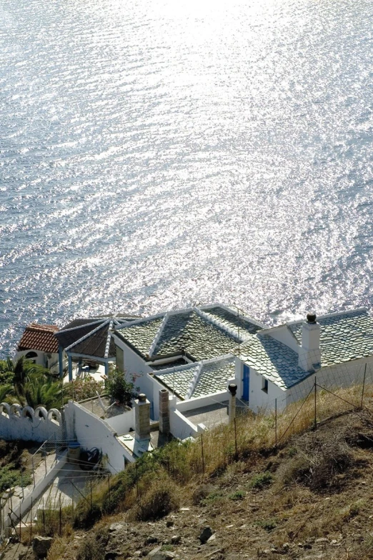 a building with a long roof is shown near the water