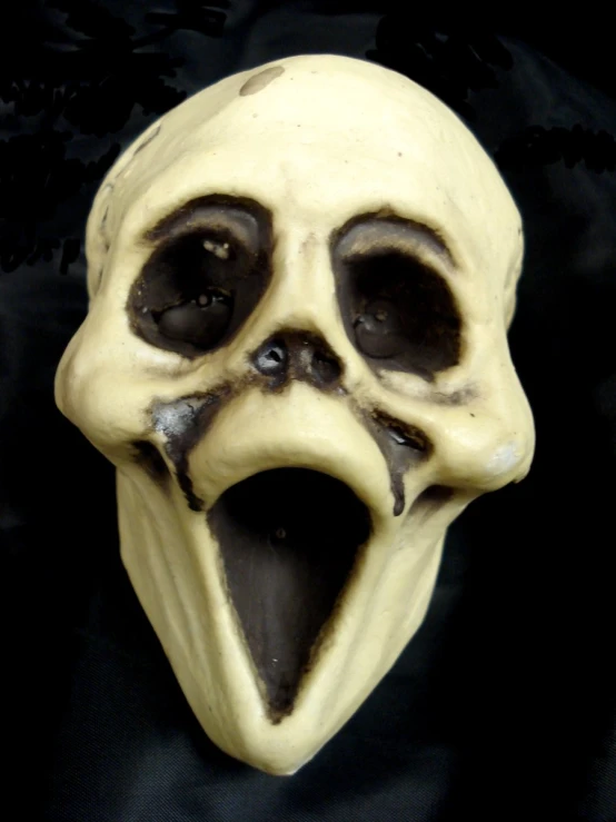 an odd looking mask has a black nose and tongue