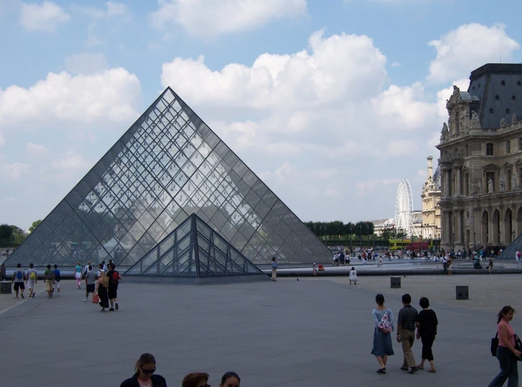 people are standing outside in front of a pyramid