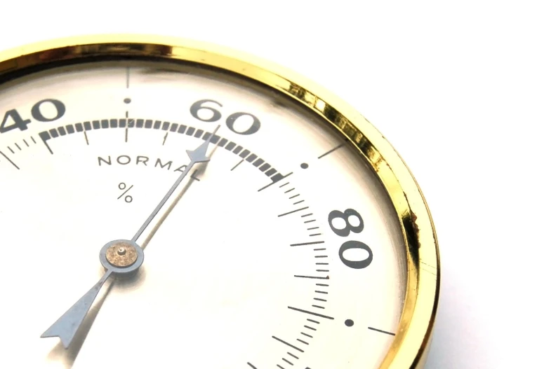 a closeup po of a white clock on a white table