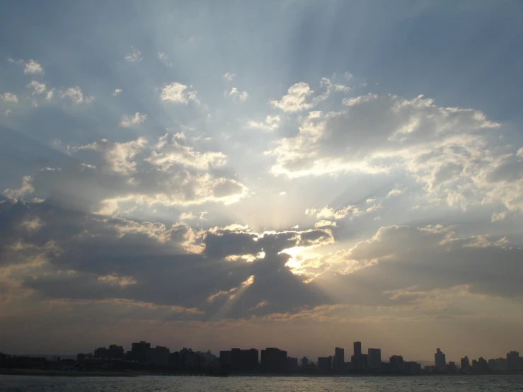 the sun shines through clouds in a cityscape