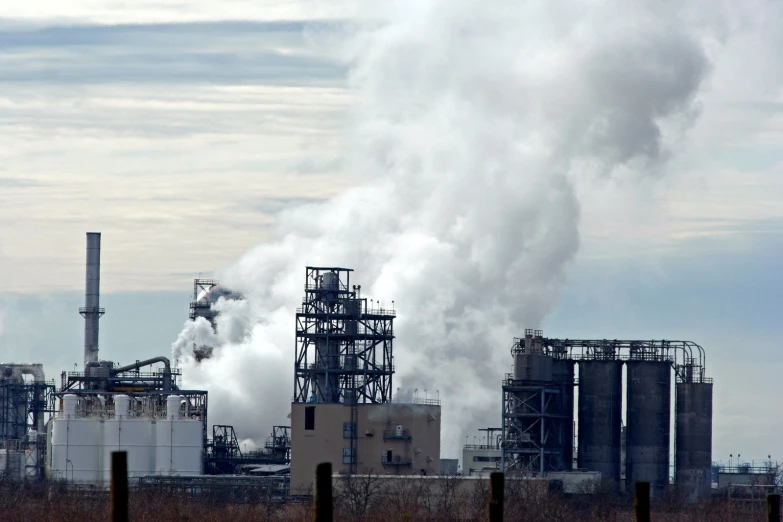 a factory that is smoking white smoke coming out of it