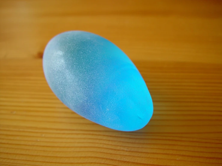 an image of a shiny blue object on a wood table