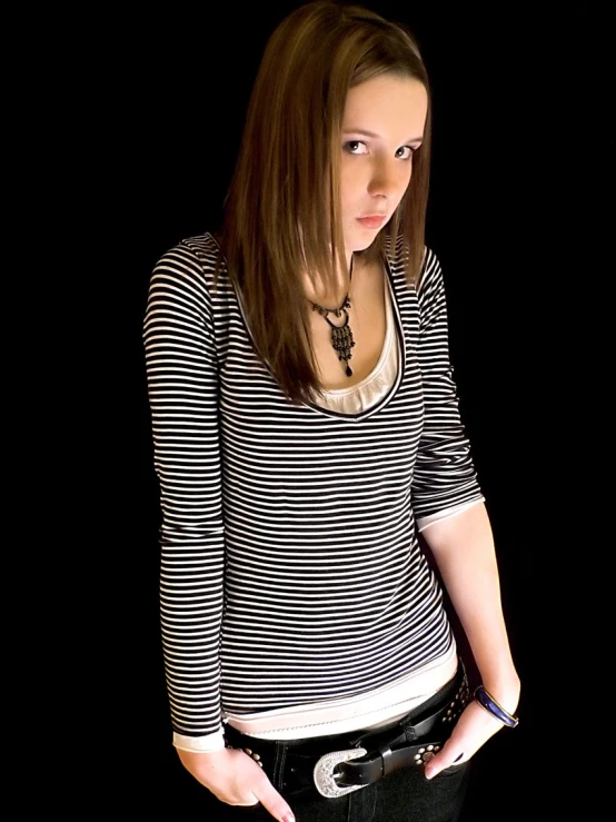woman in white and black top posing with a black background