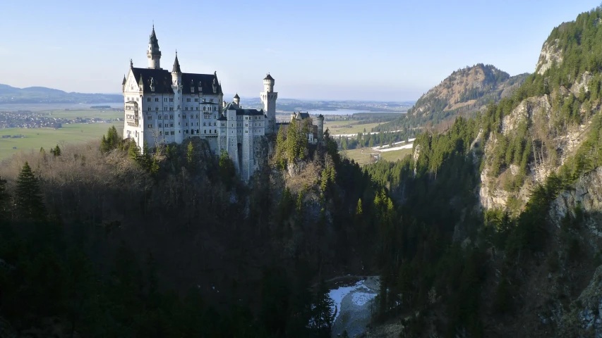 a castle with towers and some trees in front of a mountain