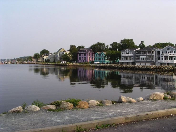 many buildings reflected in the water with trees