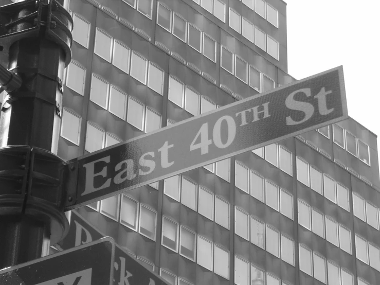 a couple of street signs on a pole with buildings in the background