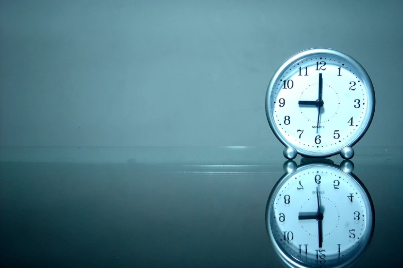 an alarm clock has reflection in a reflective surface