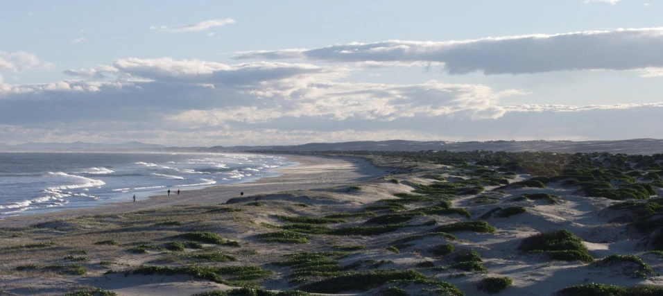 an ocean scene with people out in the distance and water in the distance