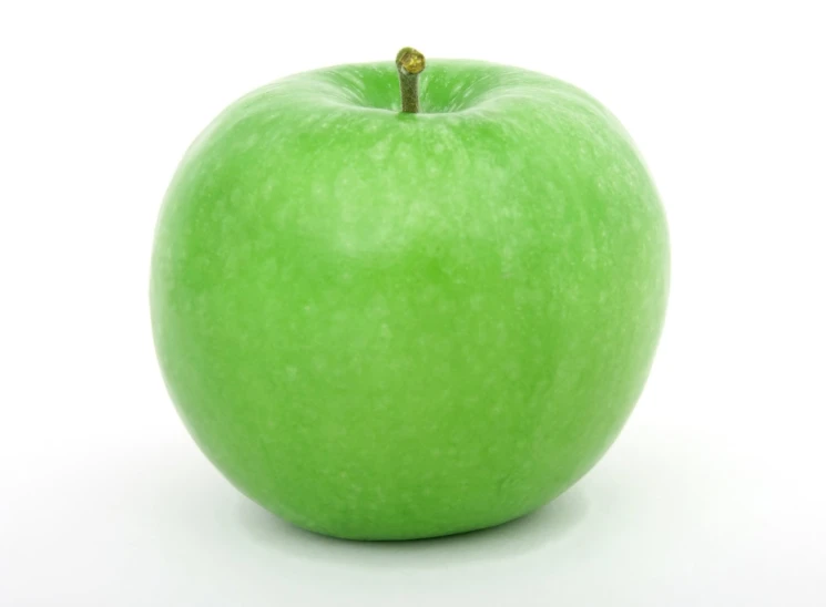 the green apple is on the white floor