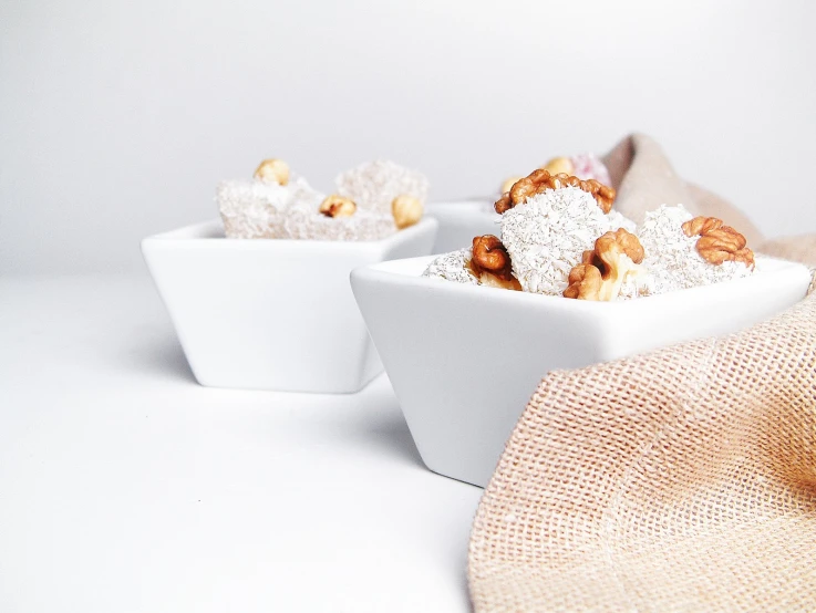 two white bowls of different kinds of foods