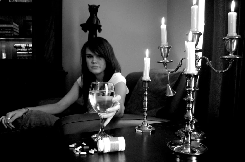 a woman sitting in a chair with two wine glasses on it