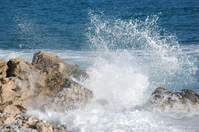 a crashing wave on rocks on the ocean