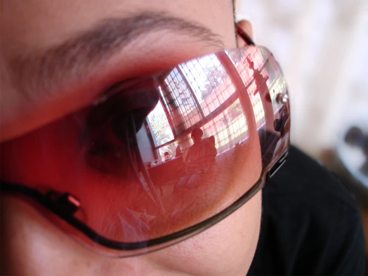 a close up of someone wearing sunglasses with their reflection in the lens