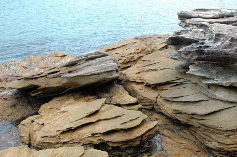 some rocks that are sitting by the water