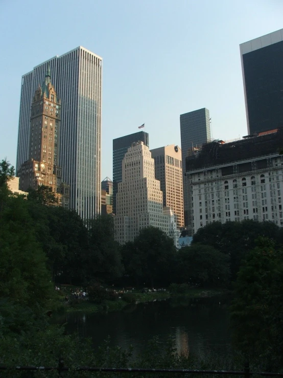 large city with skyscrs and lots of trees on the riverbank