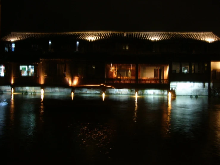 a building has lights and windows by water