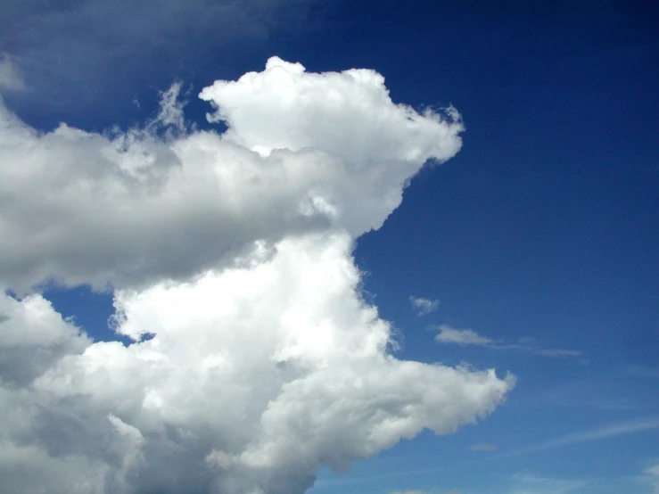 the airplane flies through the blue sky in its flight