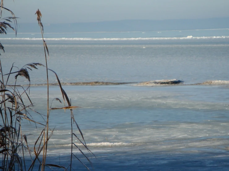 the tide is approaching the large rock on the shore