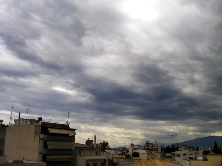 dark clouds loom over the roofs of buildings